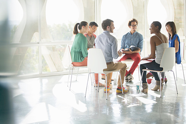 Creative business people meeting in circle of chairs